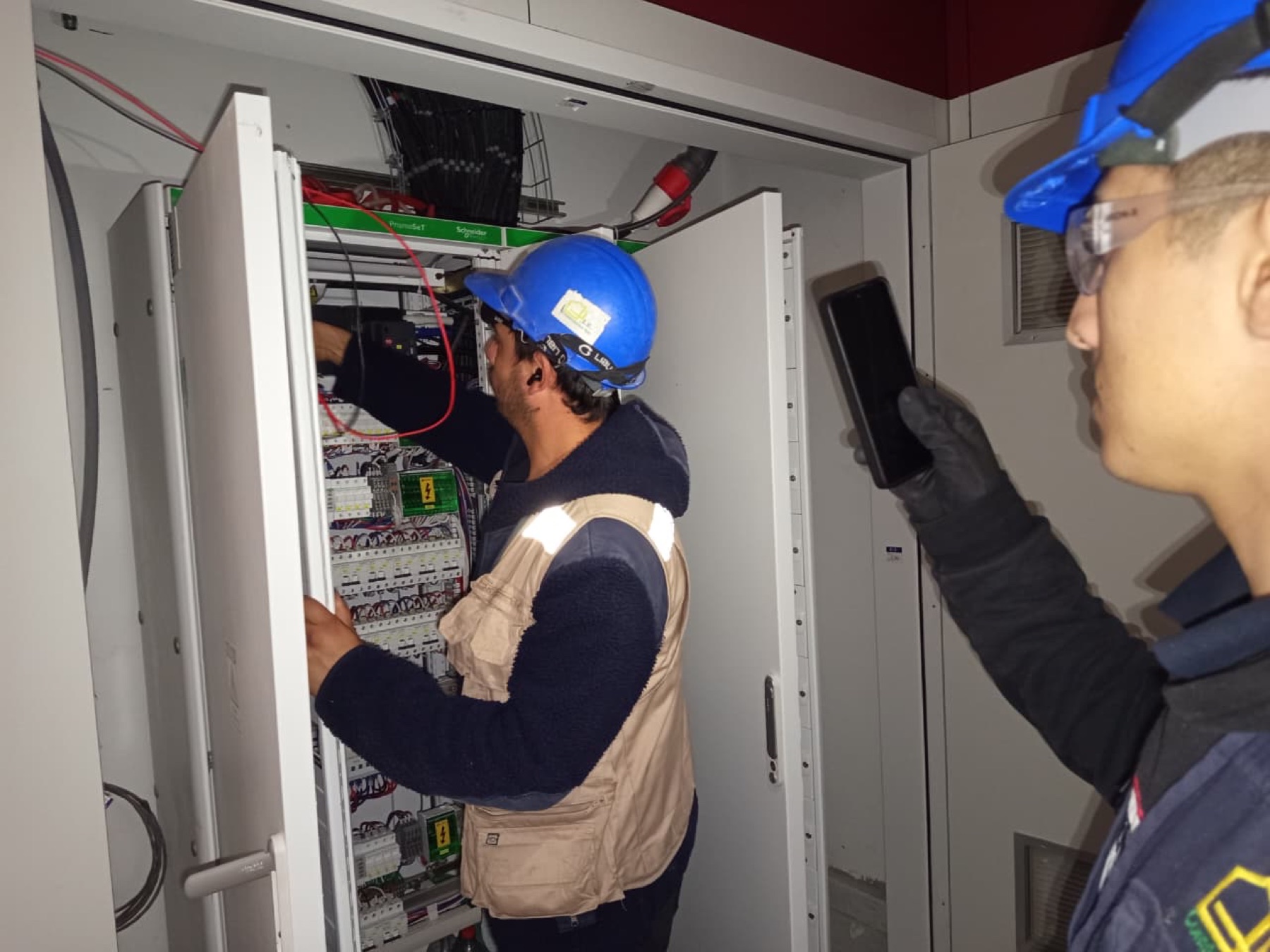 Técnicos trabajando en un tablero eléctrico de control